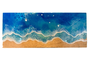  unique resin artwork captures the reflection of water and the beauty of the shoreline in a playful and quirky way. Measuring 26”x11” and ready to hang,